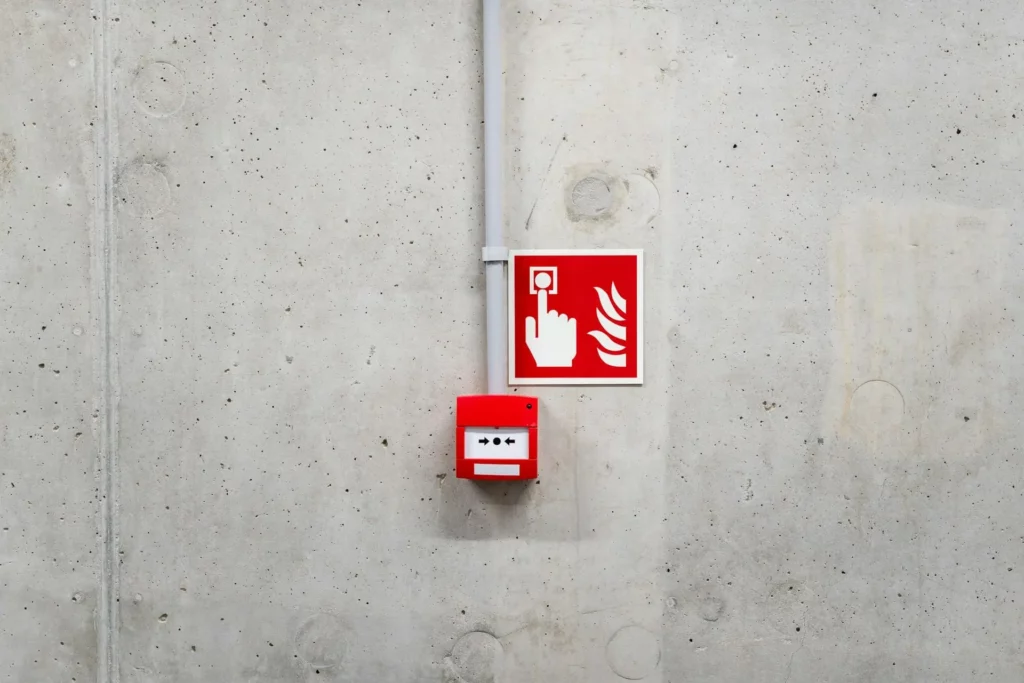 Déclencheur manuel d’alarme incendie sur un mur, utilisé pour signaler un départ de feu dans un établissement.